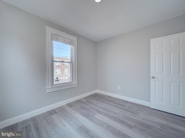 spare room featuring wood finished floors and baseboards