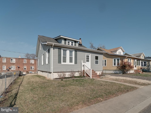 view of front of property featuring entry steps, a front yard, and fence