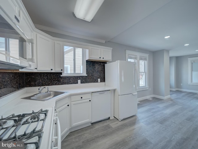 kitchen featuring tasteful backsplash, light wood-type flooring, plenty of natural light, white cabinets, and white appliances