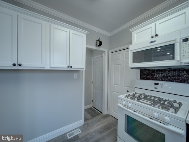 kitchen with visible vents, white cabinetry, white appliances, crown molding, and light wood finished floors