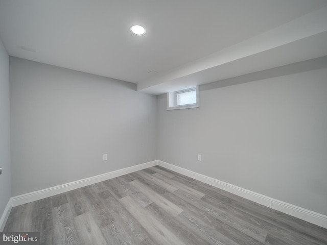 below grade area with baseboards and wood finished floors