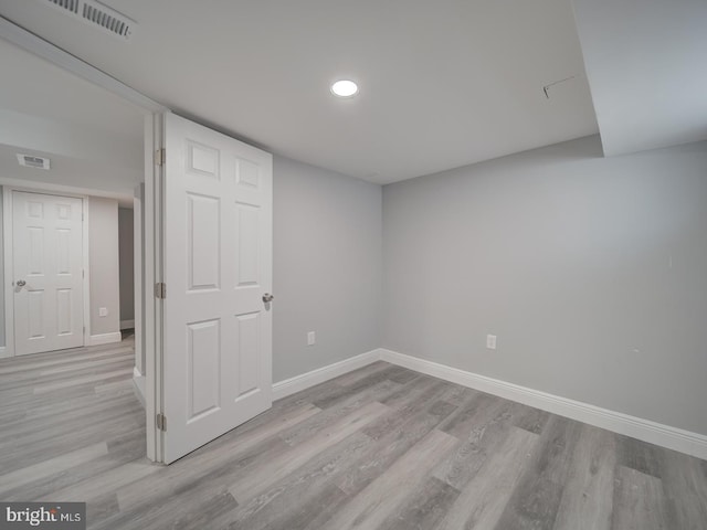 empty room featuring visible vents, baseboards, and light wood finished floors