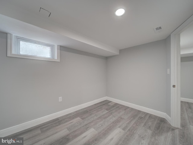 basement featuring visible vents, wood finished floors, and baseboards