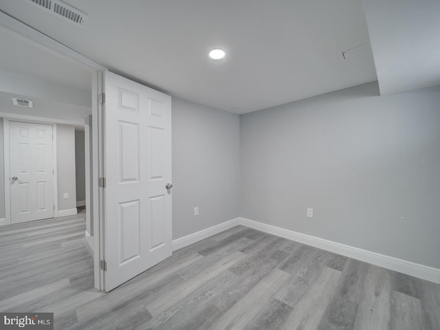 unfurnished room with light wood-type flooring, visible vents, and baseboards