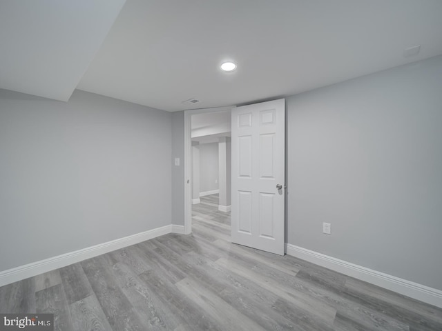 finished basement with recessed lighting, visible vents, baseboards, and wood finished floors