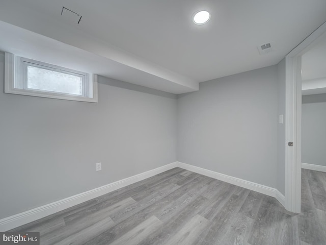 below grade area featuring visible vents, baseboards, and wood finished floors