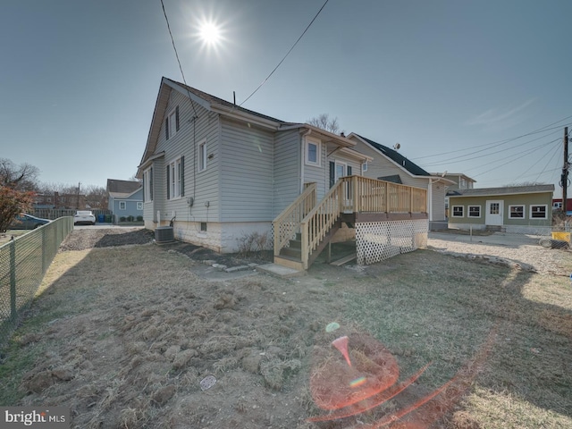 rear view of property featuring a yard, central air condition unit, a deck, and fence