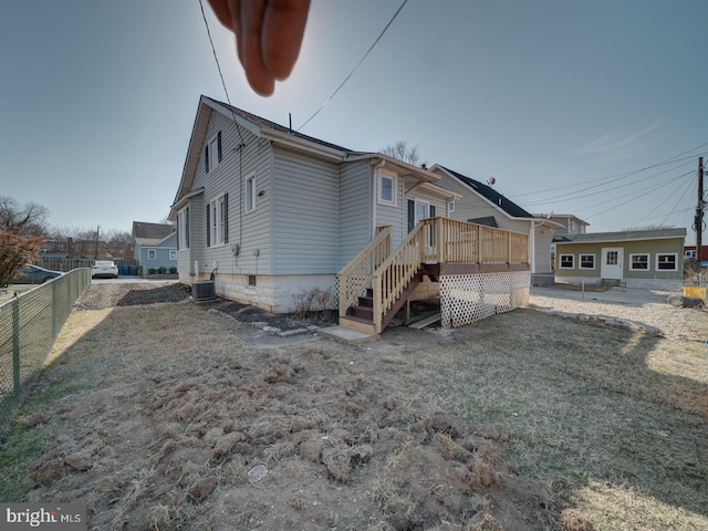 back of house with a yard, central air condition unit, a deck, and fence