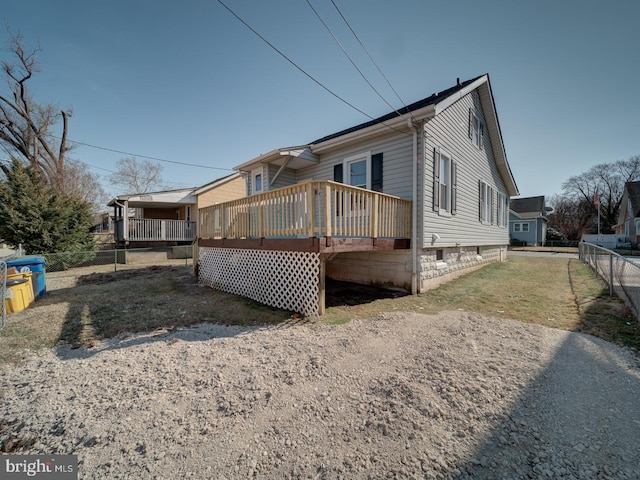 back of property with a wooden deck and fence