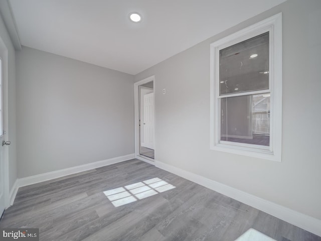 unfurnished room with baseboards and wood finished floors