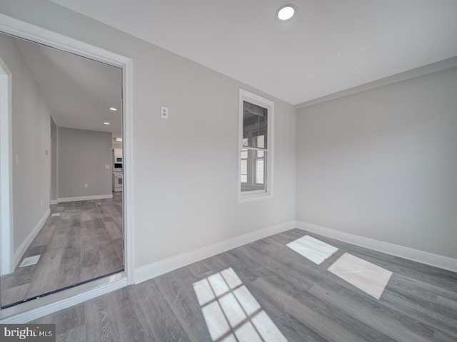 spare room featuring recessed lighting, baseboards, and wood finished floors