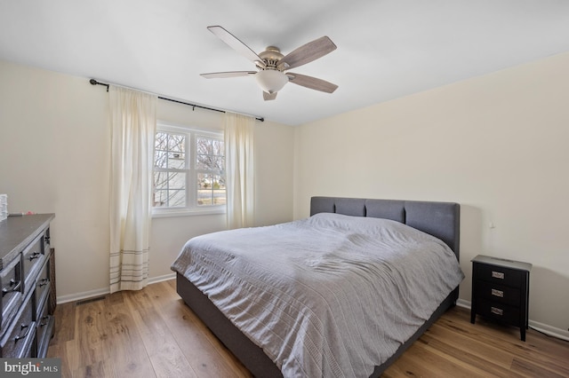 bedroom featuring ceiling fan, baseboards, and light wood-style flooring