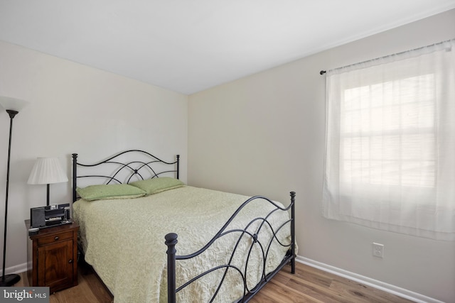 bedroom with baseboards and wood finished floors