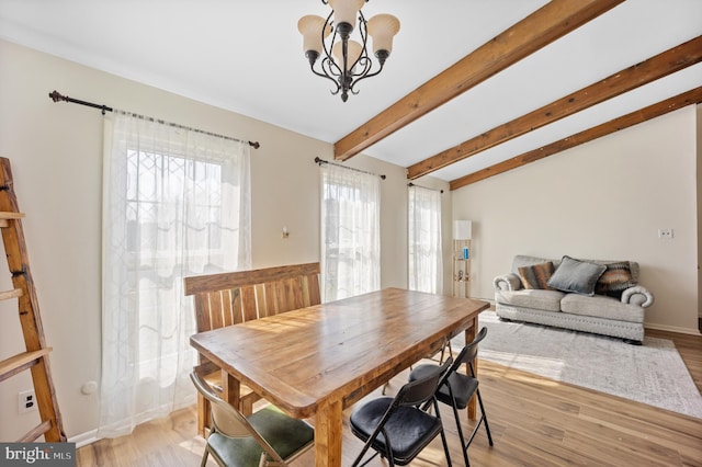 dining space featuring beamed ceiling, light wood-style flooring, baseboards, and an inviting chandelier