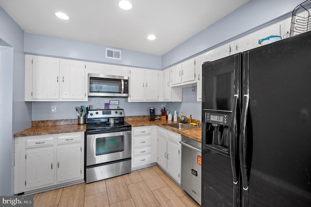 kitchen with visible vents, recessed lighting, appliances with stainless steel finishes, white cabinets, and a sink