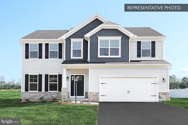 view of front facade with driveway, stone siding, a front yard, a shingled roof, and a garage