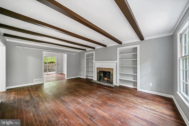 unfurnished living room with visible vents, a fireplace, baseboards, and hardwood / wood-style floors