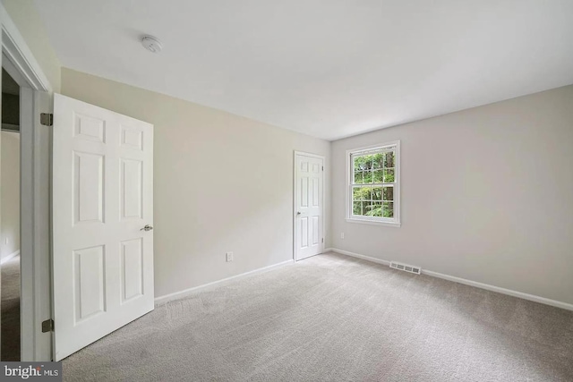 spare room featuring visible vents, baseboards, and carpet