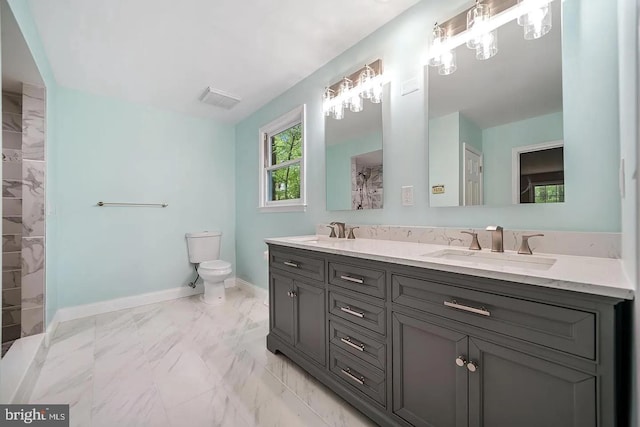 bathroom with marble finish floor, toilet, baseboards, and a sink