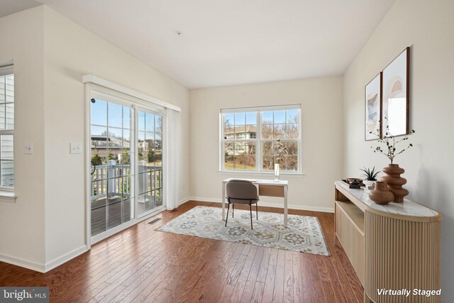 office featuring baseboards, a healthy amount of sunlight, and hardwood / wood-style flooring