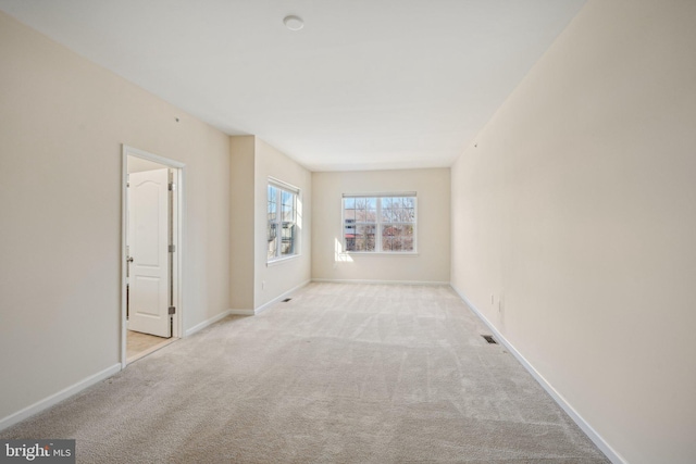 spare room featuring visible vents, carpet, and baseboards