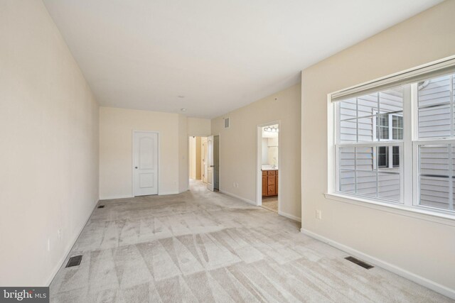 unfurnished room featuring visible vents, light carpet, and baseboards