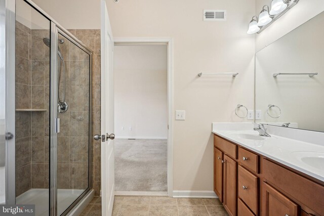 bathroom with tile patterned flooring, visible vents, a shower stall, and a sink