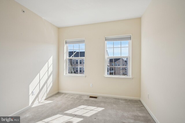 unfurnished room with visible vents, baseboards, and carpet floors