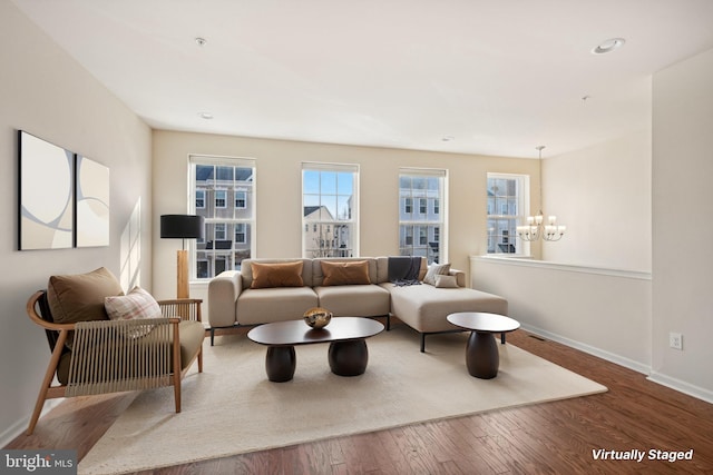 living area featuring a notable chandelier, recessed lighting, baseboards, and wood-type flooring