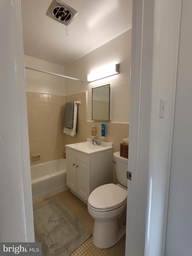 full bathroom with tile patterned flooring, toilet, vanity, shower / bathing tub combination, and tile walls