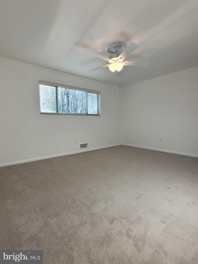 empty room featuring visible vents, baseboards, ceiling fan, and carpet flooring