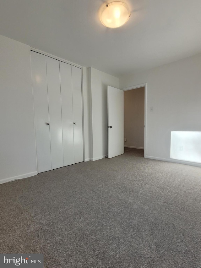 unfurnished bedroom featuring a closet, carpet flooring, and baseboards