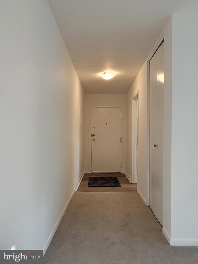 hallway featuring baseboards and carpet floors