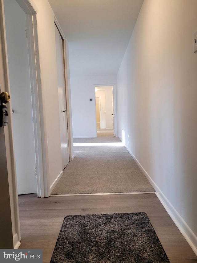 hall featuring baseboards and wood finished floors