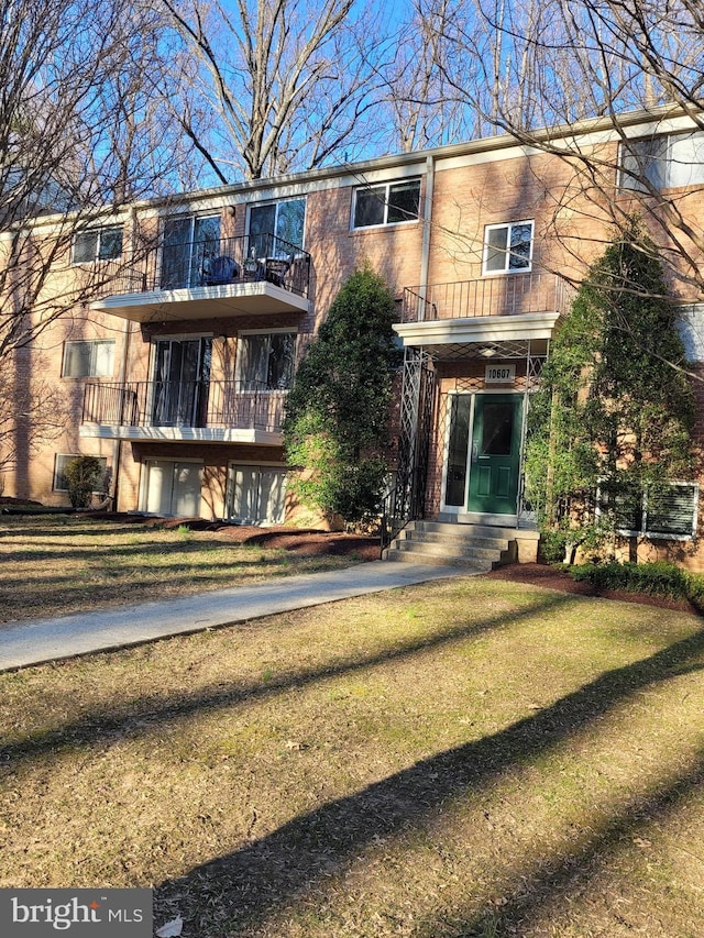 townhome / multi-family property with a balcony and a front yard