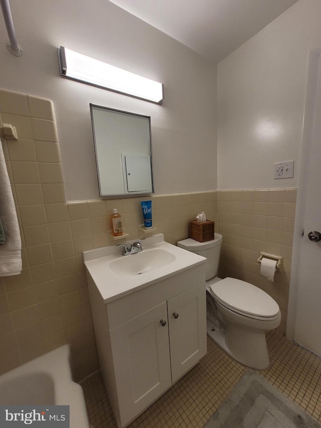 bathroom featuring tile patterned flooring, toilet, tile walls, and vanity