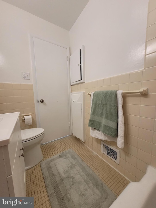 bathroom with visible vents, tile walls, a wainscoted wall, and tile patterned flooring