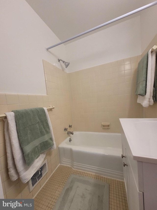 full bathroom with visible vents, shower / bathtub combination, tile walls, tile patterned flooring, and vanity