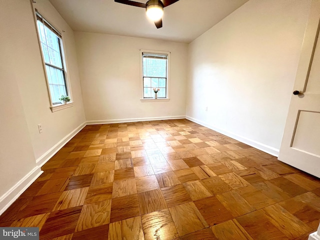 unfurnished room with baseboards and ceiling fan