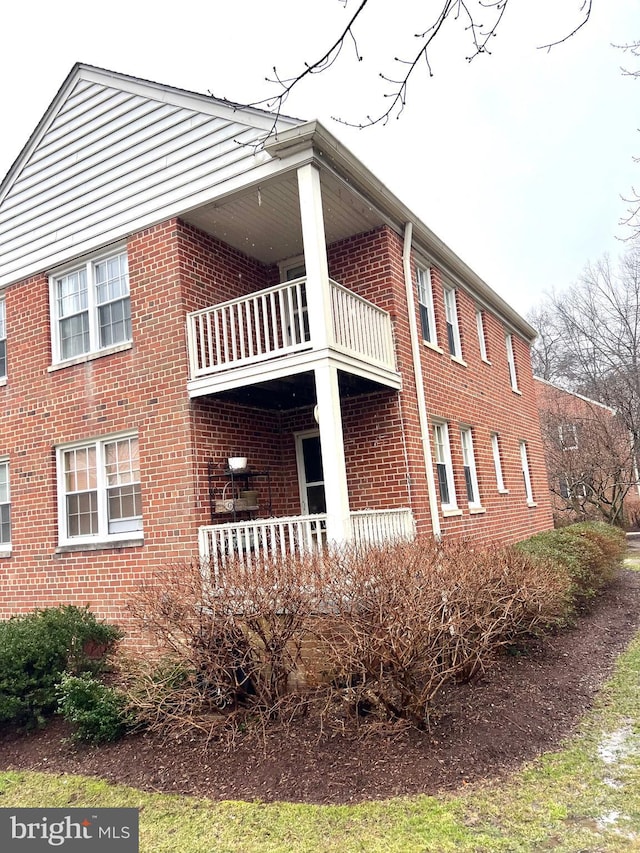 view of home's exterior with a balcony and brick siding