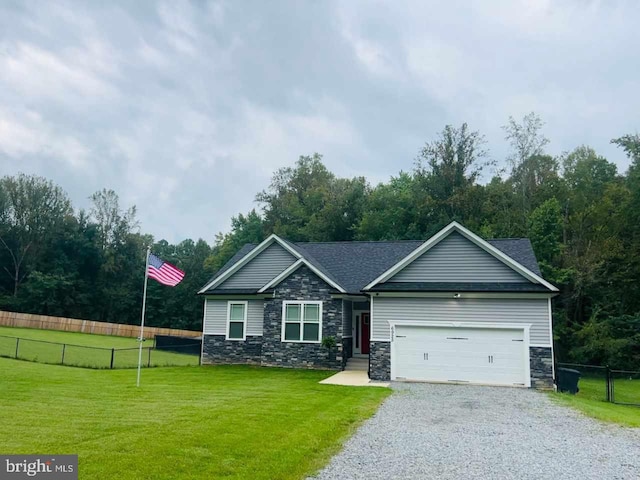 craftsman house with fence, driveway, an attached garage, a front lawn, and stone siding