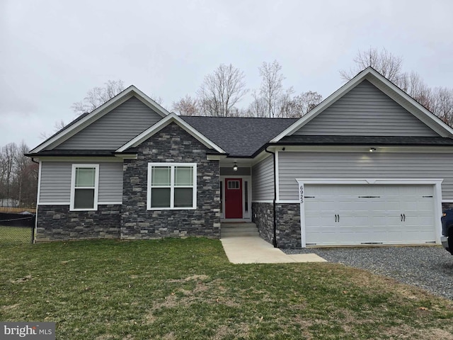 view of front facade featuring fence, gravel driveway, an attached garage, a shingled roof, and a front lawn