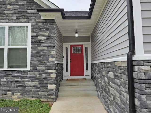 doorway to property featuring stone siding