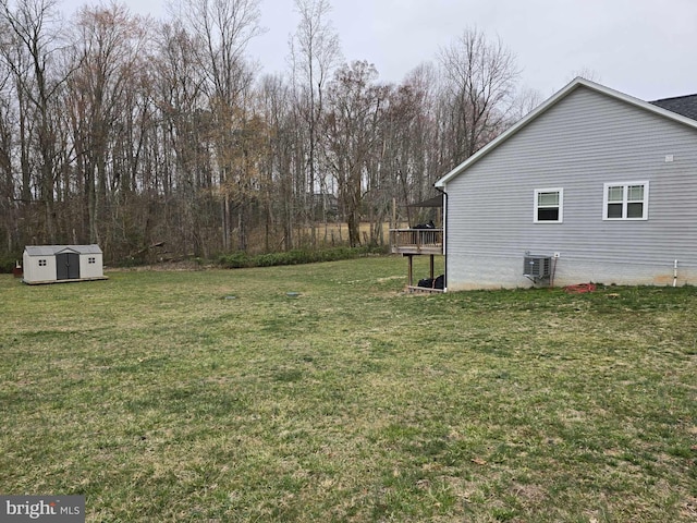 view of yard with a deck, an outdoor structure, cooling unit, and a shed