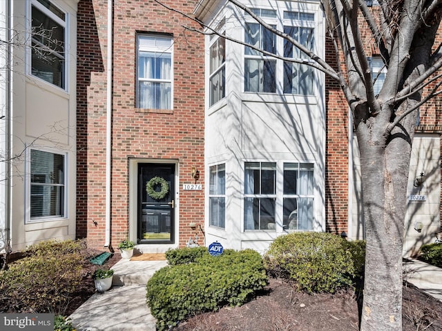 view of exterior entry with brick siding