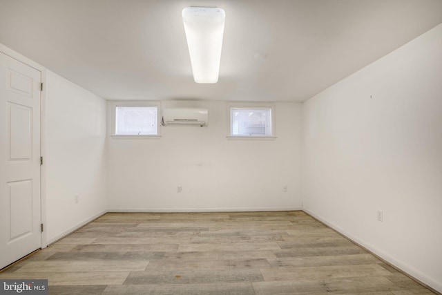 415 14th St Unit 55A, Ocean City, MD 21842 - below grade area featuring light wood-type flooring, a wall mounted air conditioner, and baseboards