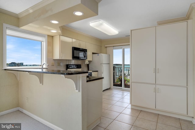 415 14th St Unit 55A, Ocean City, MD 21842 - kitchen with black microwave, range with electric stovetop, freestanding refrigerator, crown molding, and a breakfast bar