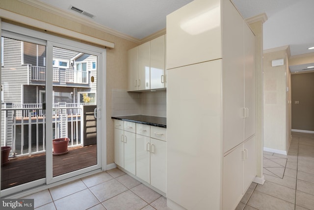 415 14th St Unit 55A, Ocean City, MD 21842 - kitchen with light tile patterned flooring, crown molding, white cabinetry, and decorative backsplash