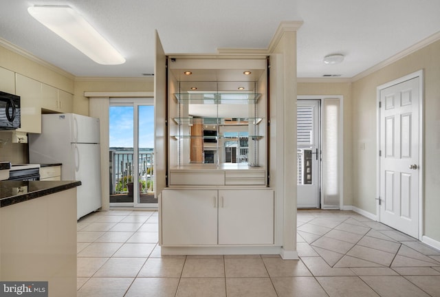 415 14th St Unit 55A, Ocean City, MD 21842 - kitchen featuring ornamental molding, dark countertops, light tile patterned floors, freestanding refrigerator, and black microwave