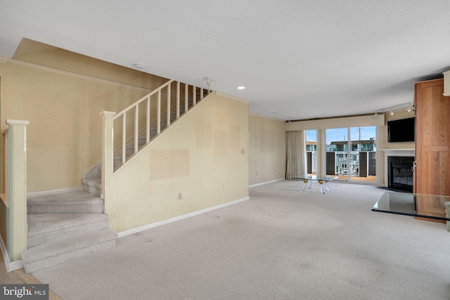 415 14th St Unit 55A, Ocean City, MD 21842 - unfurnished living room with a glass covered fireplace, stairs, carpet flooring, baseboards, and crown molding